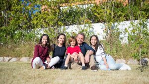 A joyful family enjoying sunny moments in a lush Portuguese garden.